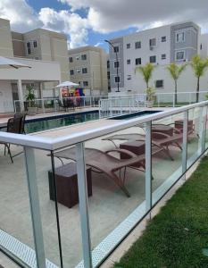 a balcony with a table and chairs and a swimming pool at Apto ao lado do Caruaru shopping 06 in Caruaru