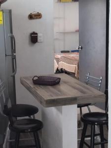 a table and two stools in a room with a kitchen at casa en playa santa clara yucatan in Santa Clara