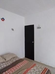 a bedroom with a bed and a black cabinet at casa en playa santa clara yucatan in Santa Clara