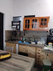 a kitchen with wooden cabinets and a sink and a microwave at casa en playa santa clara yucatan in Santa Clara
