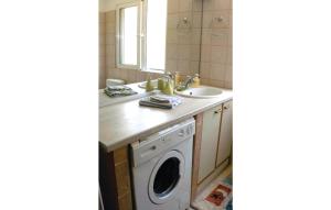 a bathroom with a washing machine and a sink at Awesome Home In Derveni With 4 Bedrooms And Wifi in Derveni