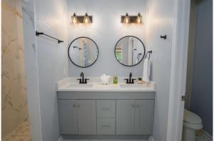 La salle de bains est pourvue de 2 miroirs et d'un lavabo. dans l'établissement Your Dream Stay 4BR2BA Near Downtown Riverwalk, à San Antonio 27 autres photos