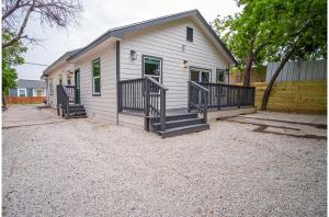 Cette petite maison blanche dispose d'une terrasse couverte et d'escaliers. dans l'établissement Your Dream Stay 4BR2BA Near Downtown Riverwalk, à San Antonio
