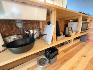 a kitchen counter with a sink and a bowl on a shelf at 西海岸オーガニック小麦畑1200坪眺望FarmStayYululu in Sumoto