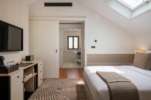 a bedroom with a large bed and a television at Casa da Marechal - Boutique Hotel by Oporto Collection - Adults Only in Porto