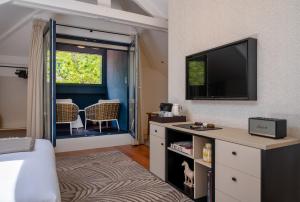 a living room with a television and a table with chairs at Casa da Marechal - Boutique Hotel by Oporto Collection - Adults Only in Porto