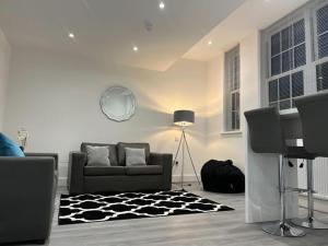 a living room with a couch and a rug at Watford City Centre Retreat - Spacious Modern Self-Contained Apartment - Sleeps 4 in Watford