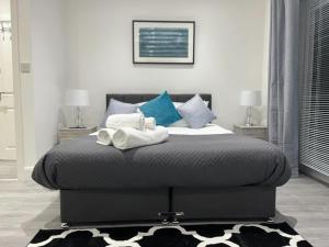 1 dormitorio con 1 cama con toallas en Watford City Centre Retreat - Spacious Modern Self-Contained Apartment - Sleeps 4, en Watford