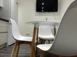 una mesa y 4 sillas blancas en una habitación en SPACIOUS & MODERN 1 bed CITY CENTRE Apartment, en Watford