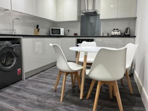 a kitchen with a table and chairs and a washing machine at Spacious & Modern CENTRAL 1 bed Apartment with OUTSIDE space in Watford