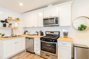 a kitchen with white cabinets and a stove top oven at Newly Remodeled 2B1B House on Historic Route 66 in Glendora