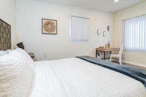 1 dormitorio con 1 cama blanca grande y escritorio en Newly Remodeled 2B1B House on Historic Route 66 en Glendora