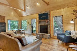 a living room with a couch and a fireplace at Gorgeous Idyllic Cabin w Hot Tub and Fire Pit Quittin Time is Secluded Romantic Oasis w Luxury Bathroom Double Shower and Bathtub Foosball Table in Broken Bow