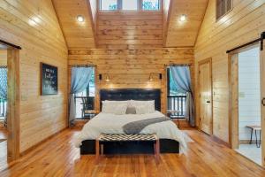 a bedroom with a bed in a room with wooden walls at Gorgeous Idyllic Cabin w Hot Tub and Fire Pit Quittin Time is Secluded Romantic Oasis w Luxury Bathroom Double Shower and Bathtub Foosball Table in Broken Bow