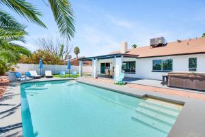- une piscine en face d'une maison dans l'établissement Greenway Villa, Newly remodeled, Pool, Putting green and Patio, à Phoenix