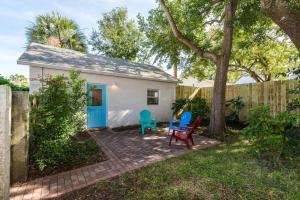 a small white shed with blue chairs in a yard at The Studio at Old Mission Walking Distance to Downtown and Onsite Parking in St. Augustine