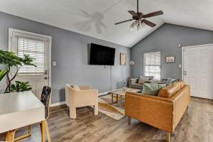 ein Wohnzimmer mit einem Sofa und einem Deckenventilator in der Unterkunft Wilmington Island Retreat in Savannah