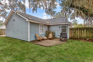 un patio trasero con terraza de madera frente a una casa en Wilmington Island Retreat en Savannah