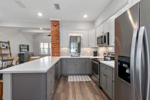a kitchen with white cabinets and a refrigerator at Oneida Charmed - Historic Cottage w Modern Flair in Saint Augustine