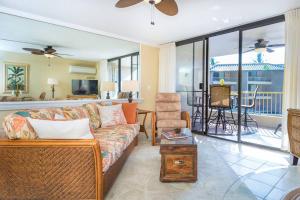 a living room with a couch and a balcony at Ocean View Condo, Stunning Views! - Kona Reef E-22 by Casago Kona in Kailua-Kona
