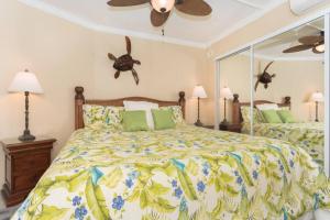 a bedroom with a bed and a ceiling fan at Ocean View Condo, Stunning Views! - Kona Reef E-22 by Casago Kona in Kailua-Kona +16 photos