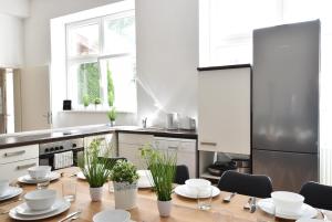 een keuken met een houten tafel met borden en planten bij Riesiges zentrales Apartment mit Parkplatz in Innsbruck