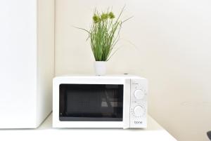 a white microwave with a plant on top of it at Riesiges zentrales Apartment mit Parkplatz in Innsbruck