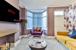 a living room with a couch and a tv at Luxury Spacious Pad with Games Room in Sheffield