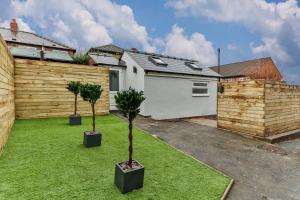 two potted trees in a yard next to a garage at Luxury Spacious Pad with Games Room in Sheffield