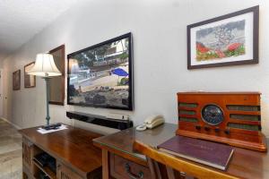 カイルア・コナにあるInviting Condo with a Stunning Ocean View! - Kona Reef C-22 by Casago Konaのデスク、テレビ、電話が備わる客室です。