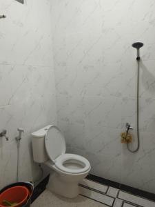 baño con aseo en una pared blanca en OYO 92561 Excellent Kost, en Jambi