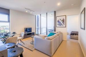 a living room with a couch and a table with chairs at Stunning Modern and Central 1BdR Apt at South Bank in Brisbane