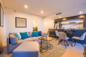 a living room with a couch and a kitchen at Stunning Modern and Central 1BdR Apt at South Bank in Brisbane