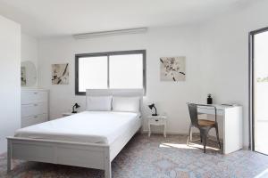 a white bedroom with a bed and a desk at Beautiful Studio in Flea Market By Holiday Rentals in Tel Aviv