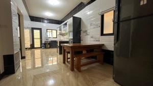 een keuken met een houten tafel en een koelkast bij Sharkat Homestay in Magong