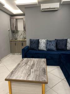 a living room with a blue couch and a table at فندق كلاسيك in Aqaba