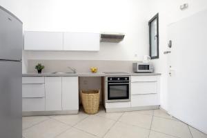 een witte keuken met witte kasten en een magnetron bij Flea Market 1BR - 30 09 Olei Zion St Tel Aviv in Tel Aviv