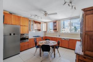 a kitchen with wooden cabinets and a table with chairs at 2BR - 2 12 Hei be-Iyar St Tel aviv in Tel Aviv