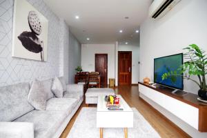 a living room with a couch and a tv at QMP Friendly House PKB in Hanoi