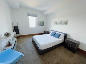 een slaapkamer met een bed en een blauwe stoel bij 2BR Suite at The Grand Castle Pool Gym & Parking in Grandville
