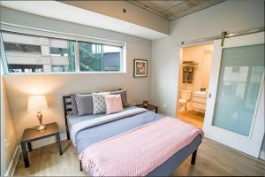 a bedroom with a bed and a window at Modern 2 BR with Balcony in GR Entertainment District in Grand Rapids