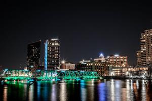 a bridge over a river in a city at night at Modern 2 BR with Balcony in GR Entertainment District in Grand Rapids