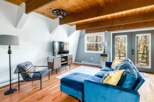 a living room with a blue couch and a tv at Private Lake&Beach Cabin, Golf, Fire Pit, & WiFi! in Terra Alta