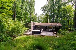 a small house in the middle of a forest at Secluded Oasis w Hot Tub, Screened-in Porch, WiFi! in Berkeley Springs