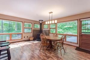 a dining room with a table and chairs and windows at Secluded Oasis w Hot Tub, Screened-in Porch, WiFi! in Berkeley Springs