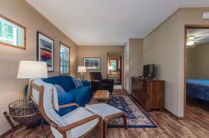 a living room with a blue couch and a bed at Secluded Oasis w Hot Tub, Screened-in Porch, WiFi! in Berkeley Springs