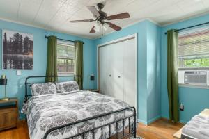 a bedroom with blue walls and a bed with a ceiling fan at Modern Cabin w Hot Tub Fire Pit WiFi in Berkeley Springs