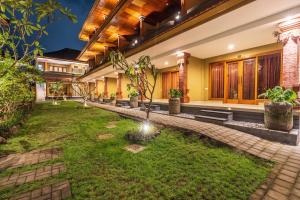 a courtyard of a house with a garden at Suka Beach Inn in Kuta