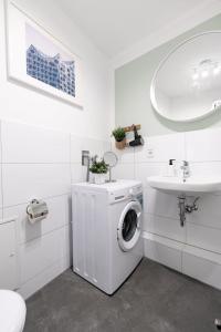 a white bathroom with a washing machine and a sink at Hamburg City Apartment for 5 in Hamburg