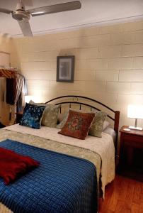 um quarto com uma cama com um cobertor azul e almofadas em J & Ella's Holiday House - 2 Bedroom Stays em Cooktown